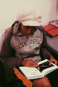 A focused young leader reading a leadership guide in a cozy home office.