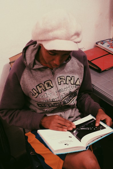 Focused student studying with books and laptop, preparing for municipal guard exam.