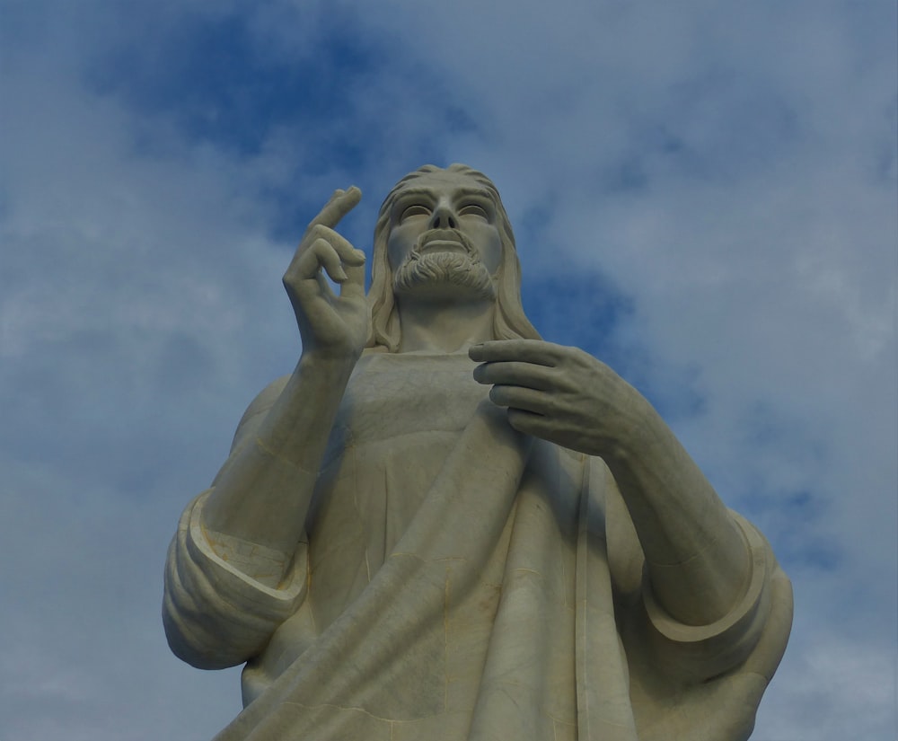 low angle photography of angel statue under blue sky during daytime