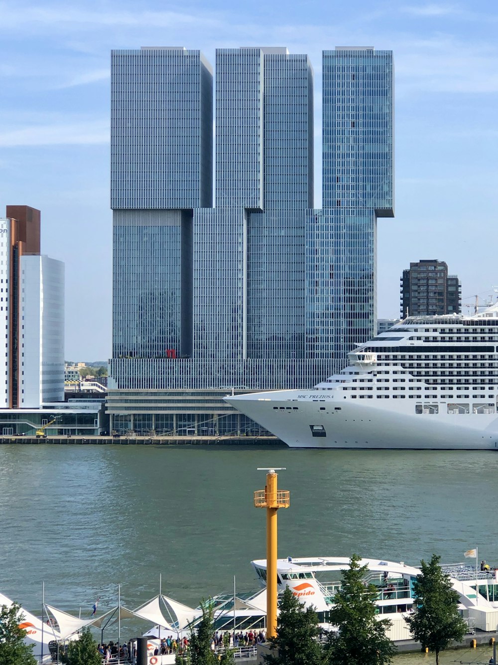 white cruise ship on water near city buildings during daytime