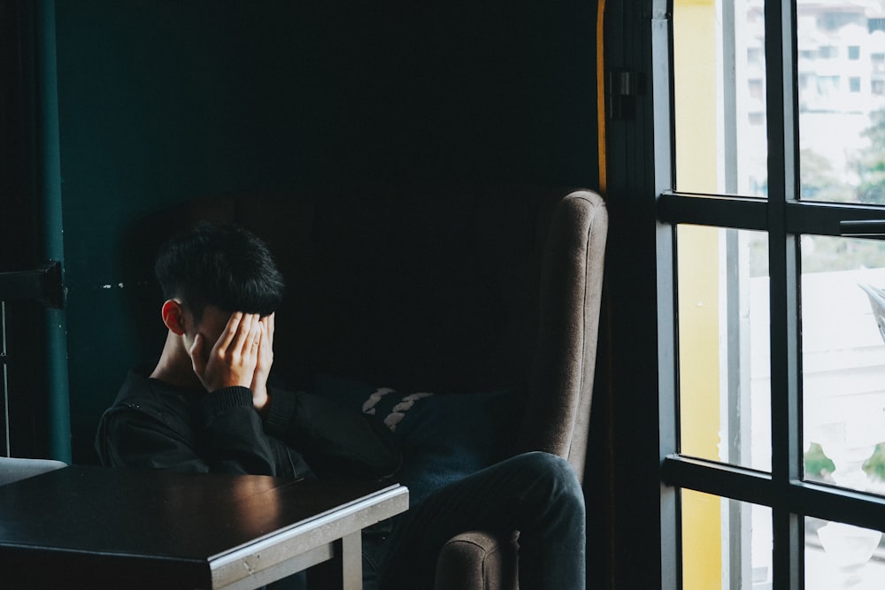 man in black jacket sitting on chair