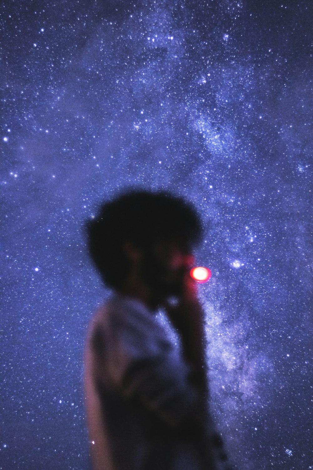 man in gray hoodie standing under starry night