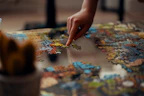 person holding jigsaw puzzle piece