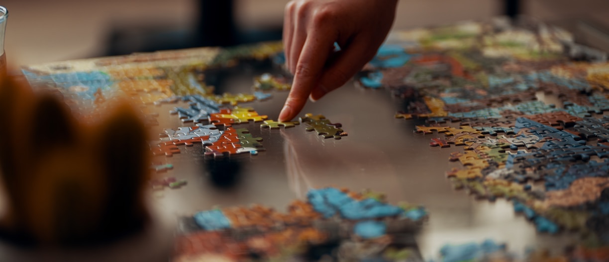 person holding jigsaw puzzle piece