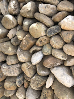 A pile of smooth, decorative stones in various natural colors ready for delivery