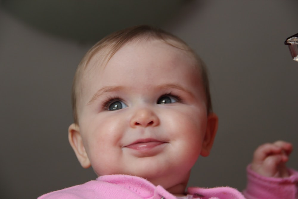 baby in pink shirt smiling