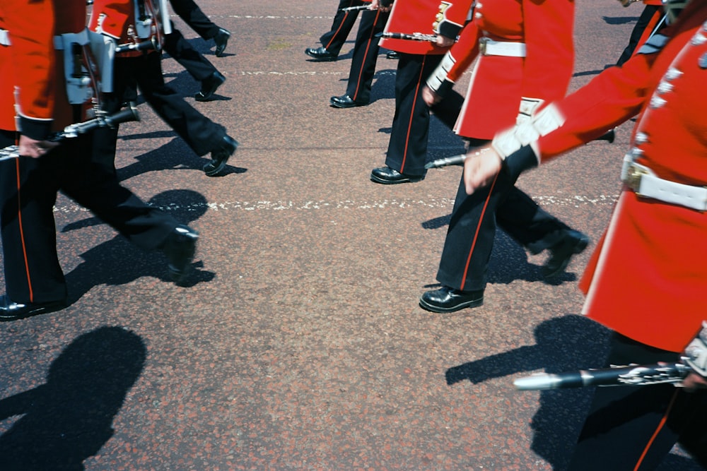 people in red and black uniform standing on gray concrete floor during daytime