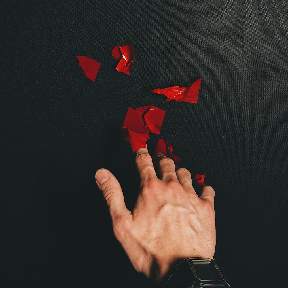red paper heart on persons hand