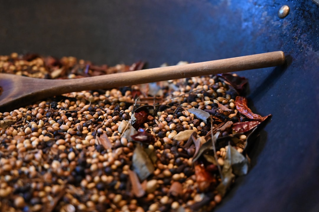 brown and black stones on black round plate, Making of roasted curry powder