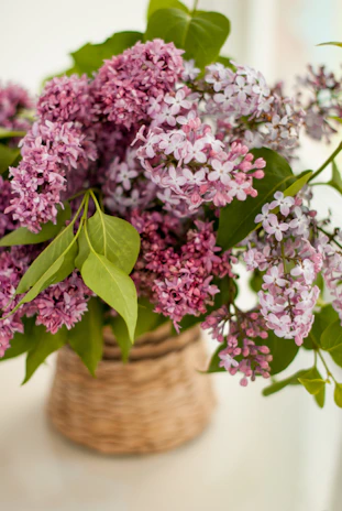 A romantic gift basket featuring soft lilac flowers and personalized cards on a light background.