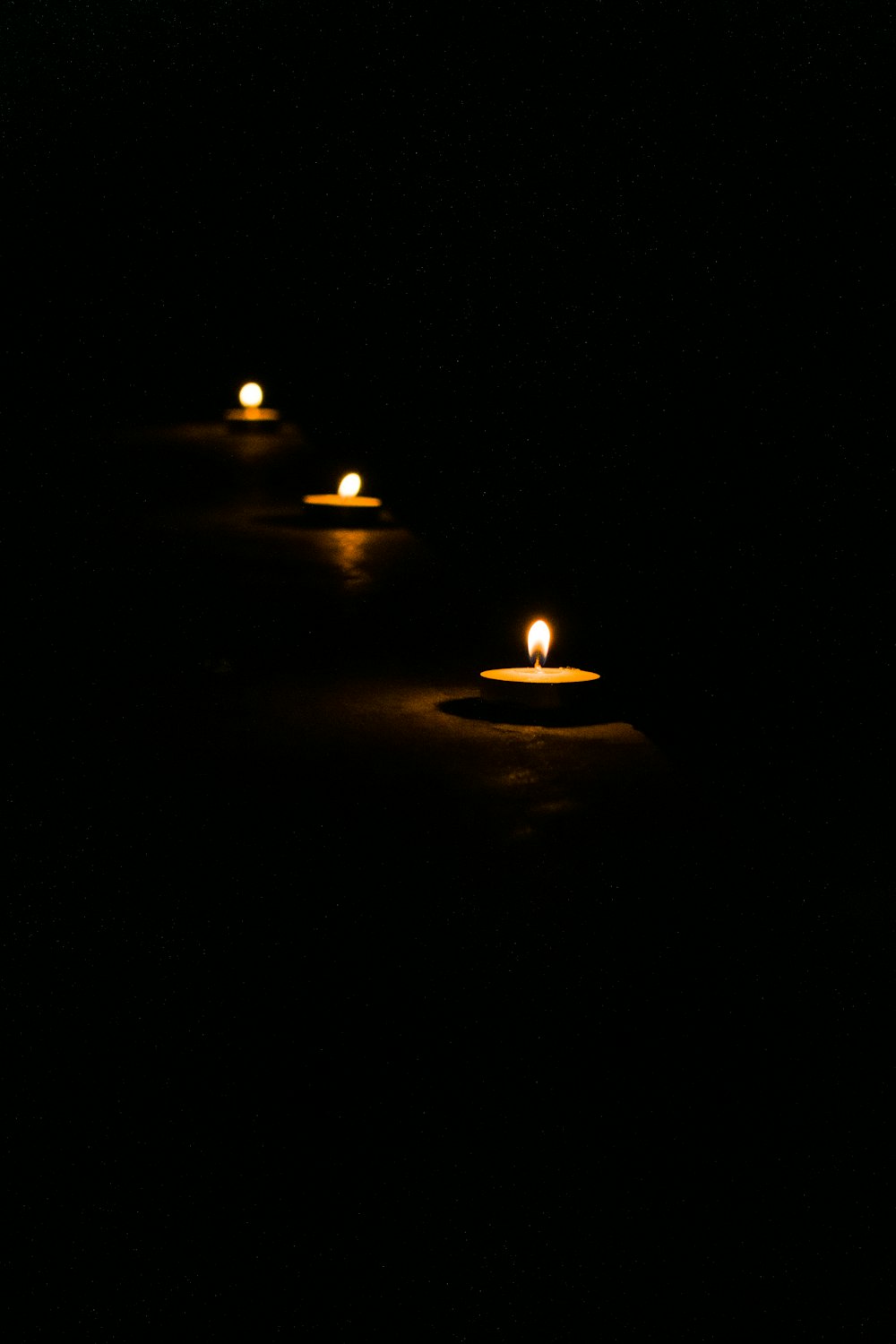 lighted candle in the dark