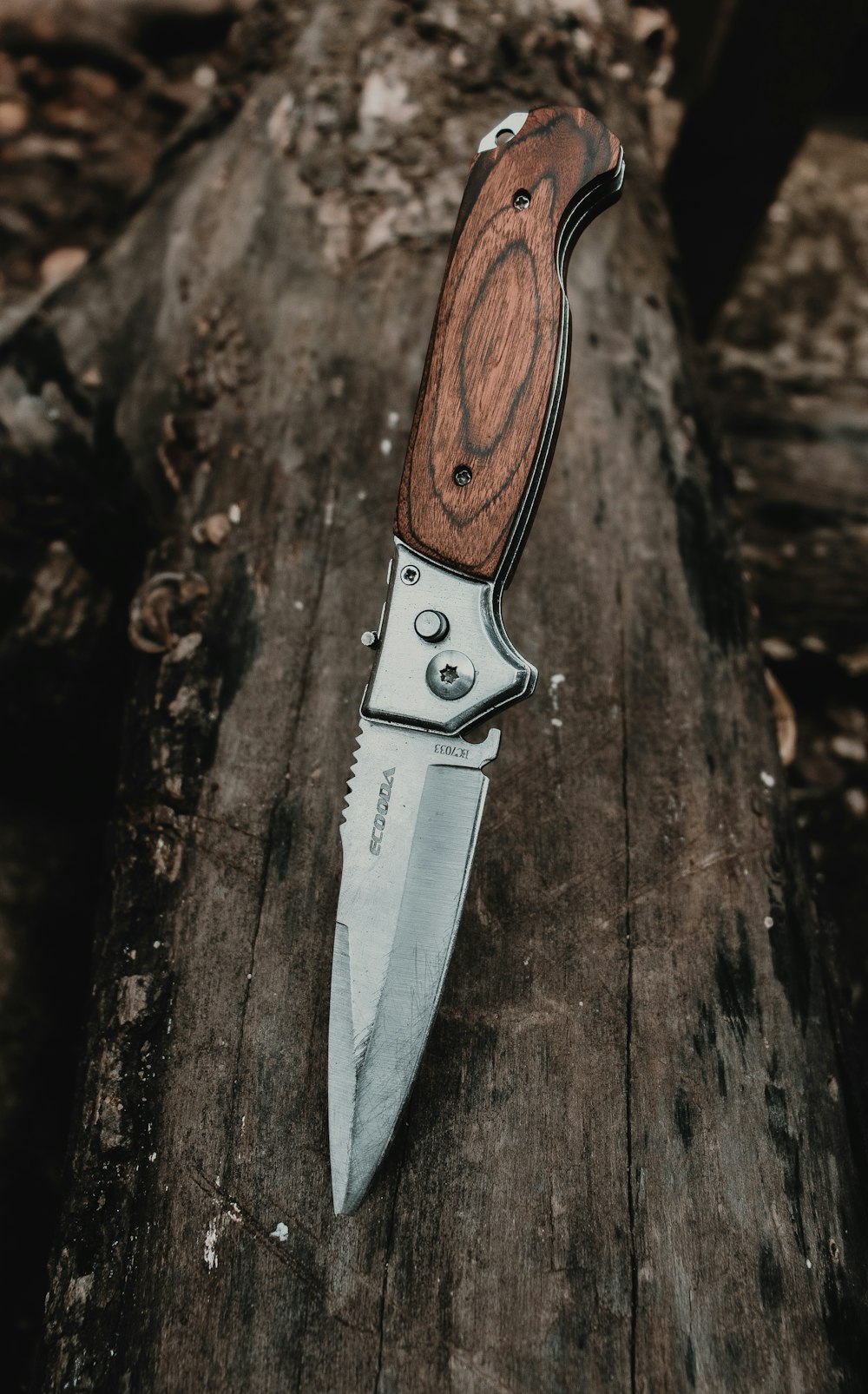 Cuchillo plateado con mango marrón sobre superficie de madera marrón