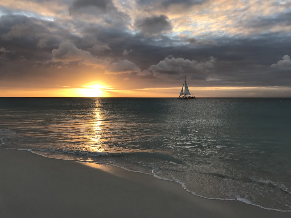 Velero en el mar durante la puesta de sol