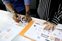 person in blue shirt writing on white paper