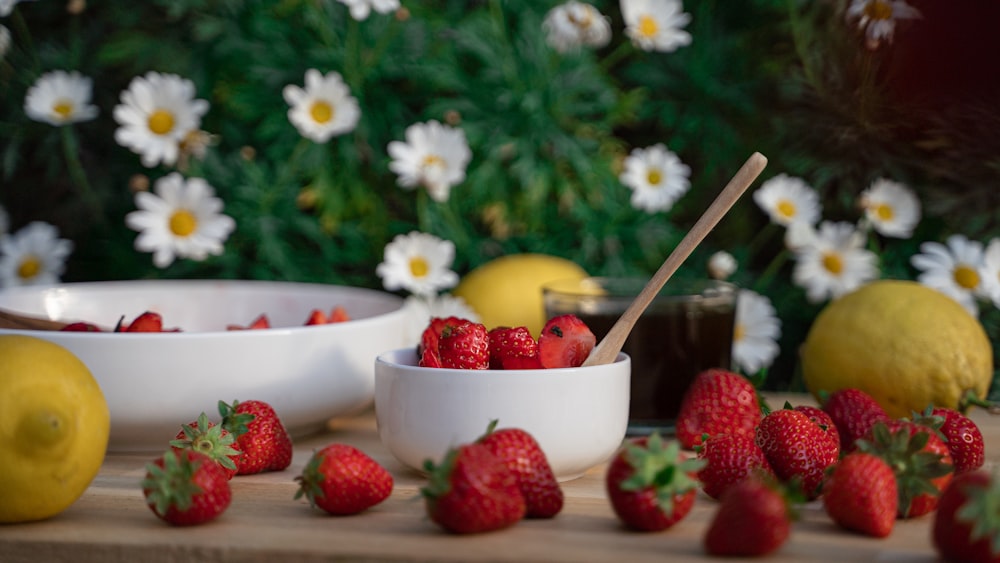 strawberries and yellow flowers in white ceramic bowl