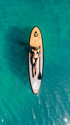 white and black surfboard on body of water