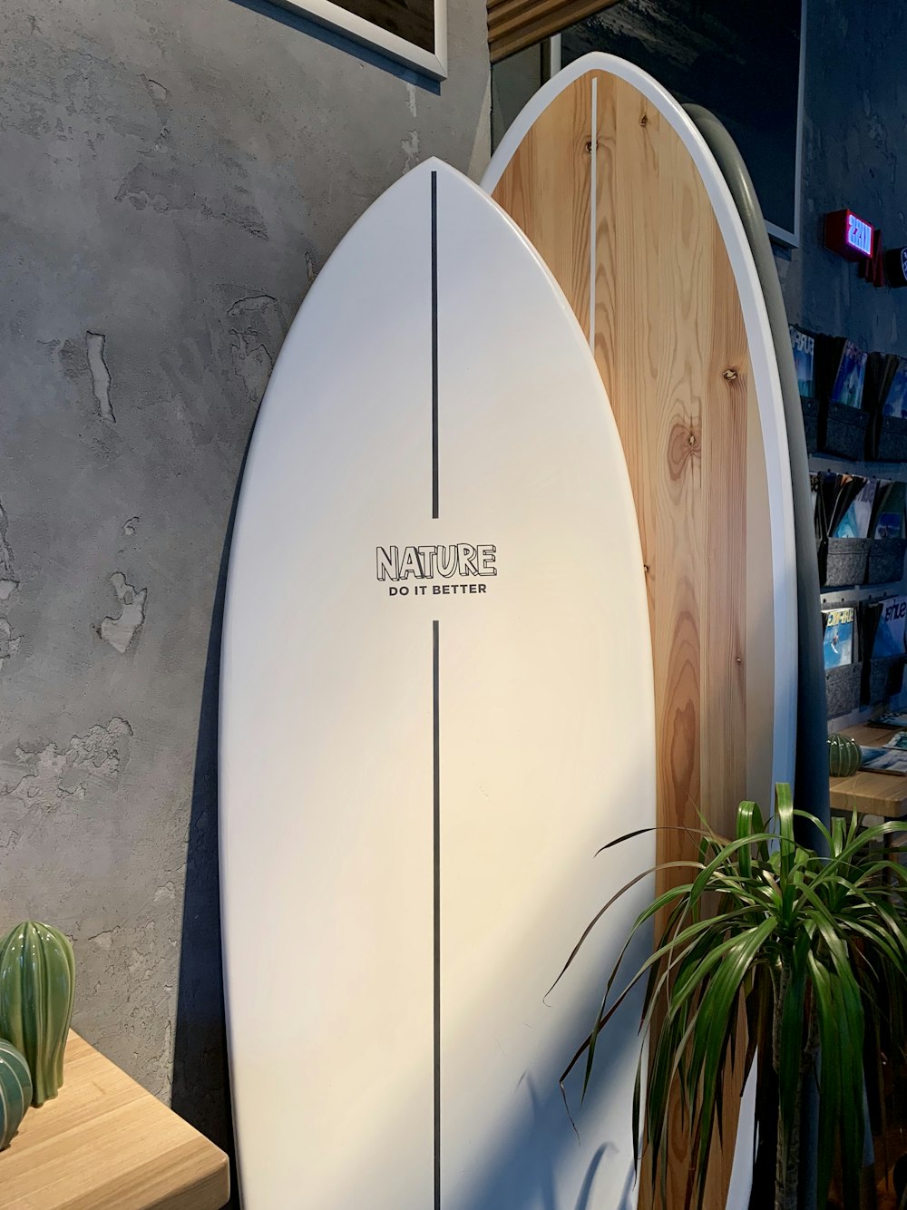 흰 벽에 기대어 있는 하얀 서핑보드