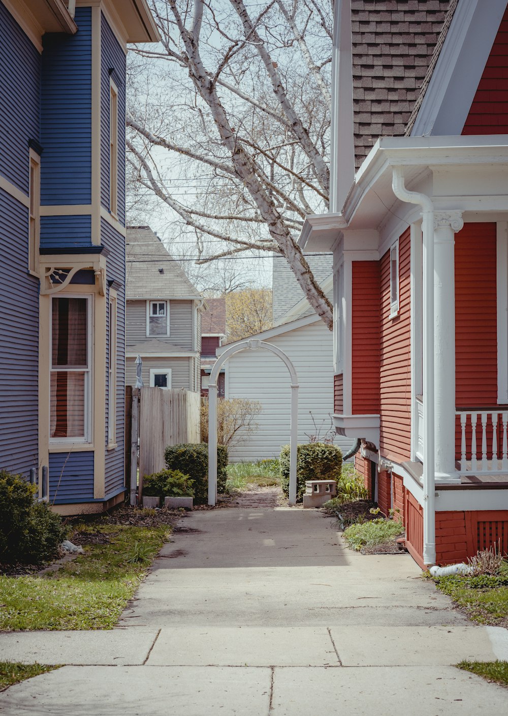 white and red wooden house near bare trees during daytime