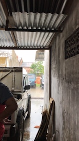 Close-up of a tow truck carefully pulling a car out of a tight garage space.