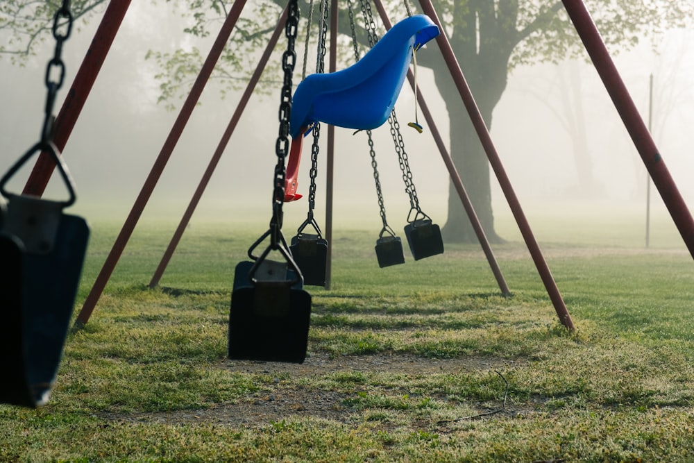 blue swing on green grass field during daytime