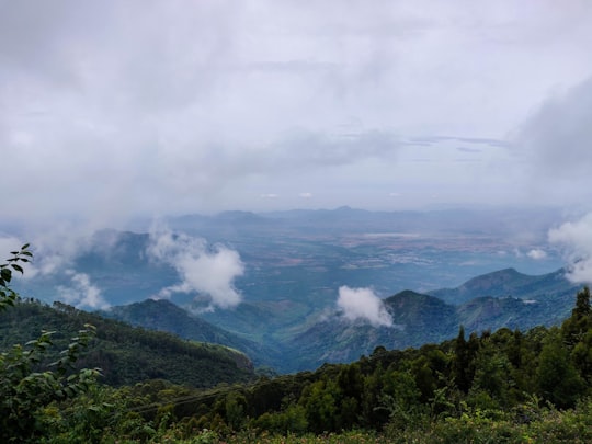 green mountains under white clouds during daytime in Kodaikanal India