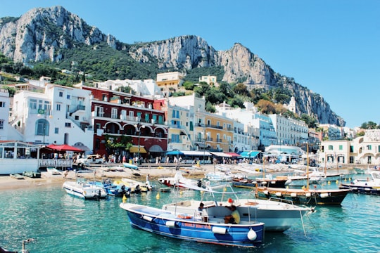 white and blue boat on body of water near buildings during daytime in Capri Italy