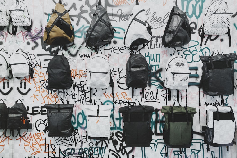 black and brown backpacks on wall