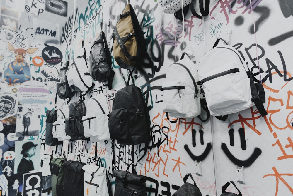 white and black backpack hanged on wall