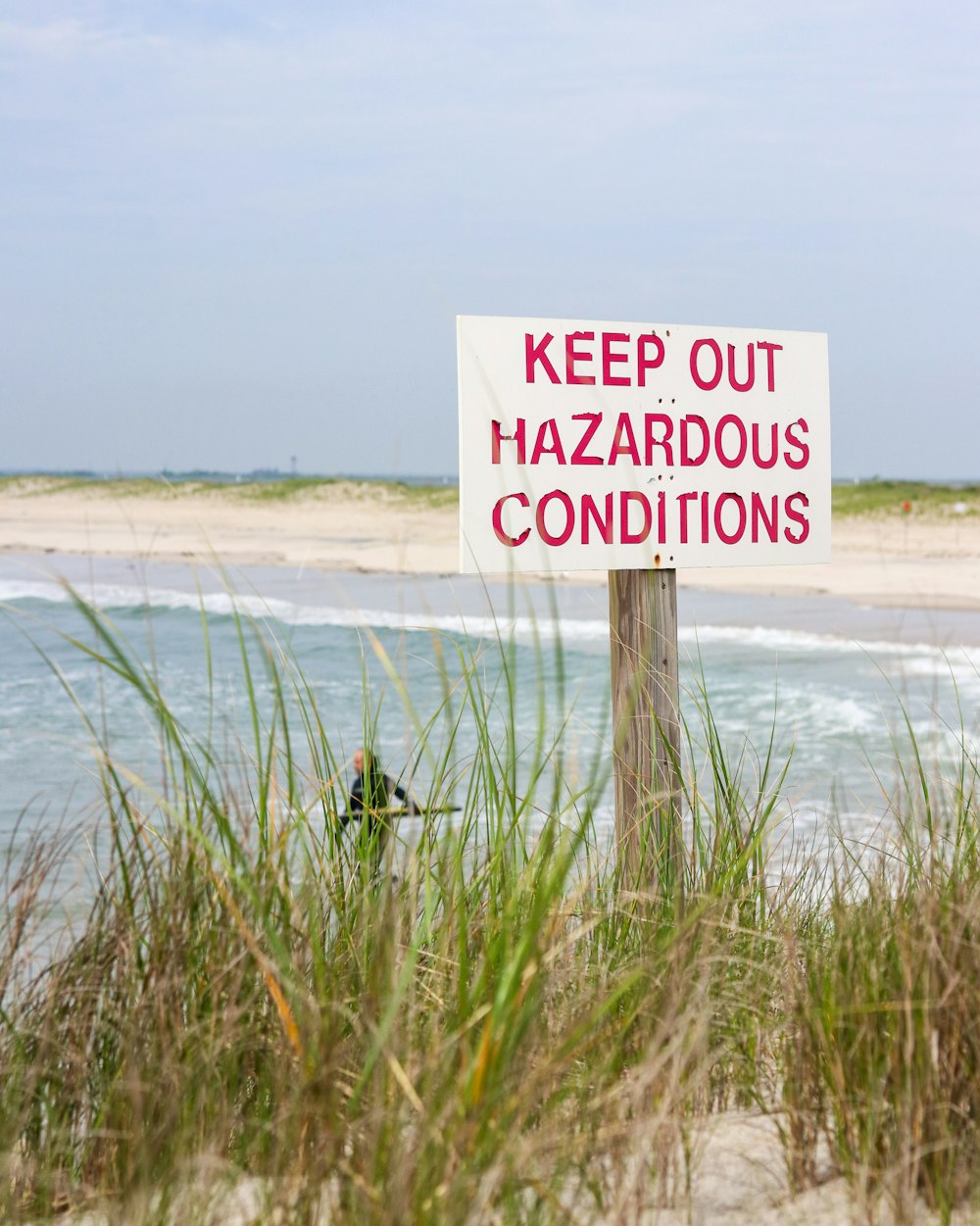 white and red no smoking no smoking sign on green grass field near body of water