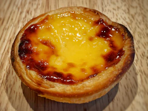 Fresh fruit-topped tart with a golden crust and a light cream filling, glowing under soft natural light
