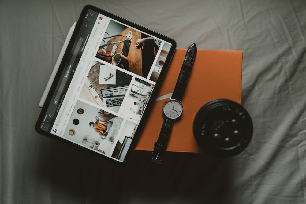 black ipad beside black round analog watch