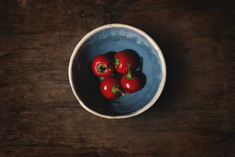 red cherry fruits on blue ceramic bowl