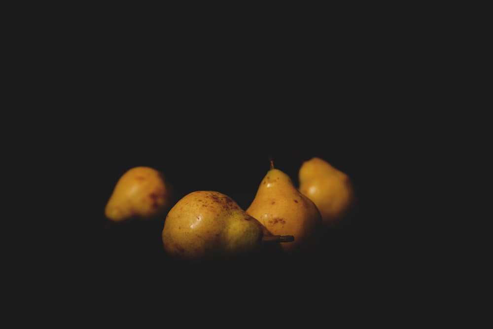 two yellow fruits on black background