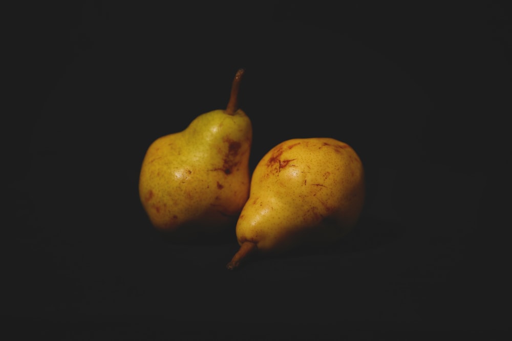 two yellow and green pear fruits