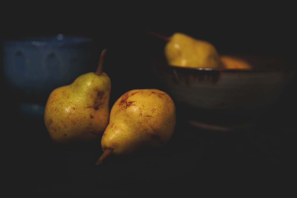 two yellow pear fruits on blue ceramic bowl