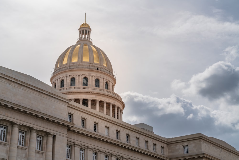 white concrete dome building under white clouds during daytime