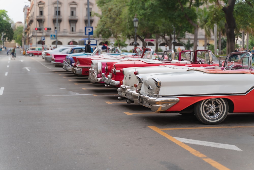 red and white vintage cars on road during daytime
