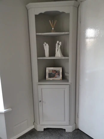 Compact utility space showcasing a Farrow & Ball warm grey paint finish, with neatly arranged shelves and a practical work surface.