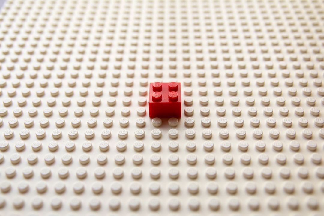 red plastic toy on white textile