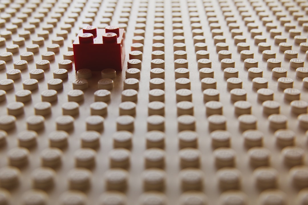 red plastic toy on white textile