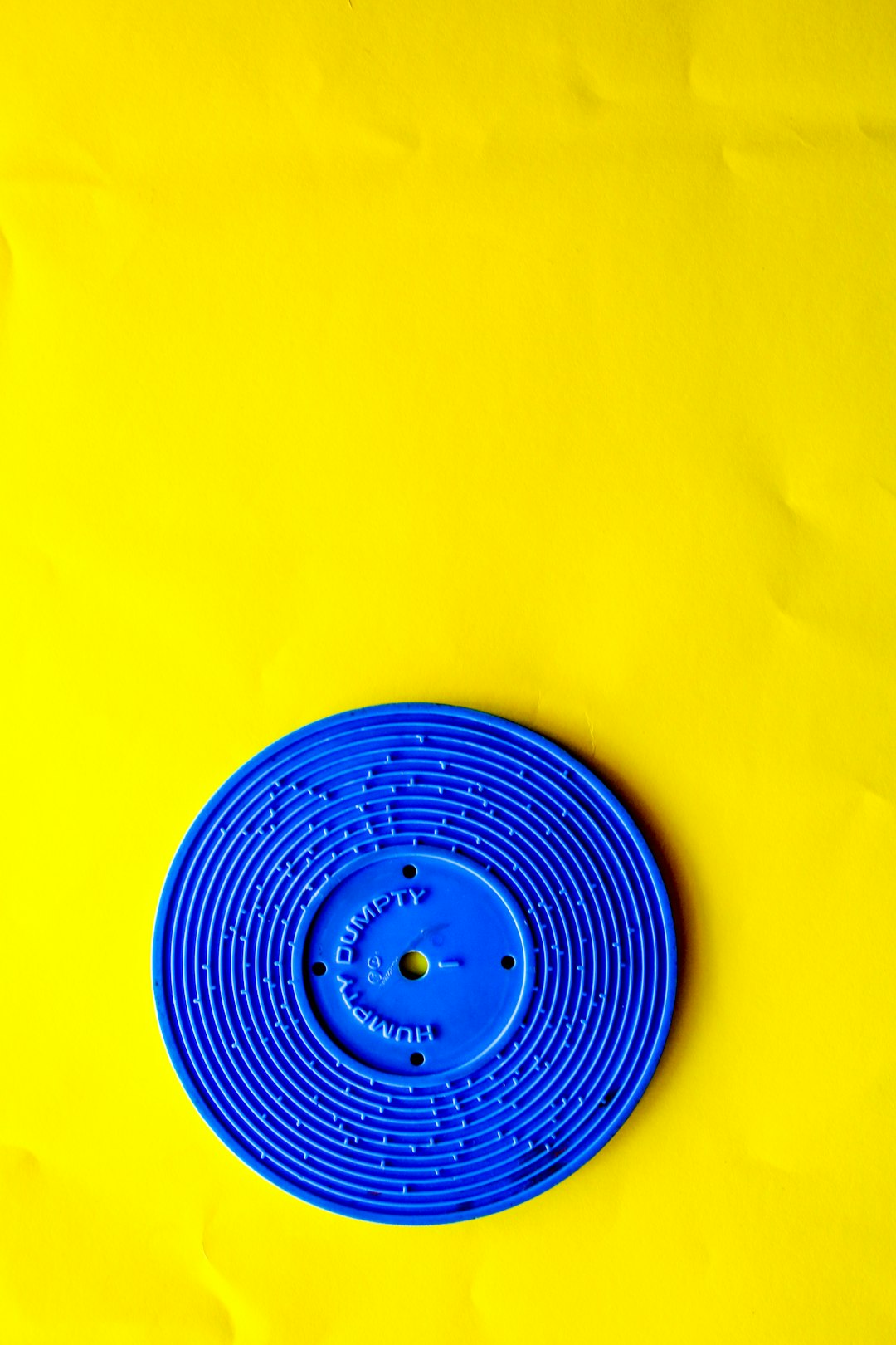 blue round plastic lid on yellow textile