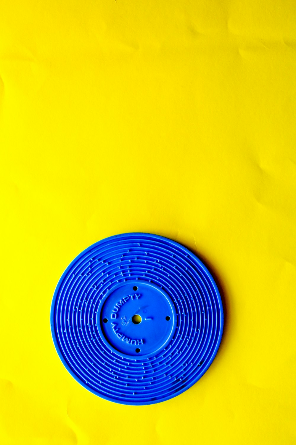 Couvercle rond en plastique bleu sur textile jaune