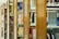 A series of wooden bookshelves filled with a variety of books organized vertically. The image captures a library setting with clear signs of academic or educational content, given the visible titles and categorization of the books.