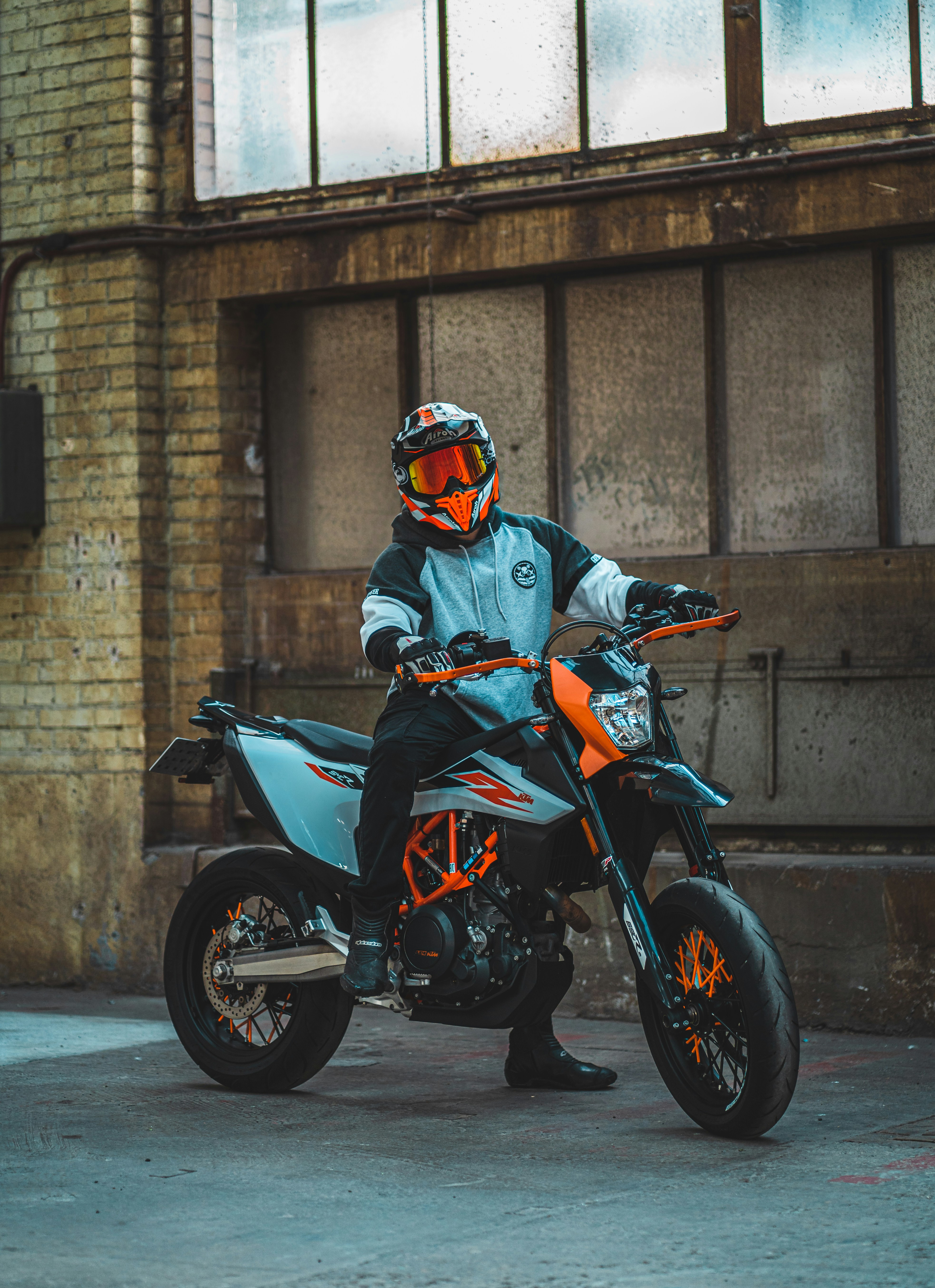 黒いバイクに乗る黒とオレンジ色のオートバイのヘルメットの男の写真 Unsplashの無料schweiz写真