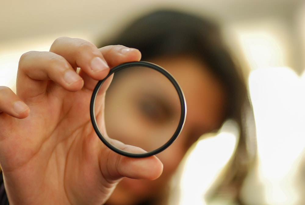 person holding black round frame