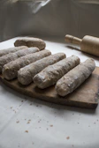 Close-up of freshly rolled dough for traditional Indian snacks on a wooden board.