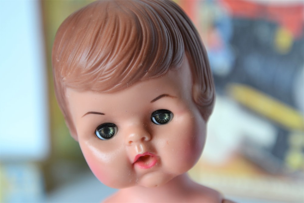 brown haired girl doll in close up photography