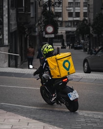 man in yellow helmet riding black motorcycle on road during daytime