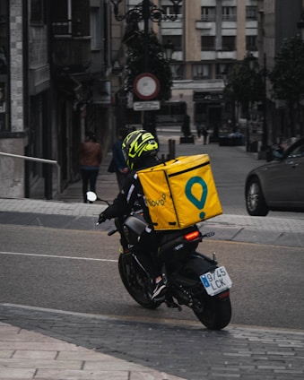 man in yellow helmet riding black motorcycle on road during daytime