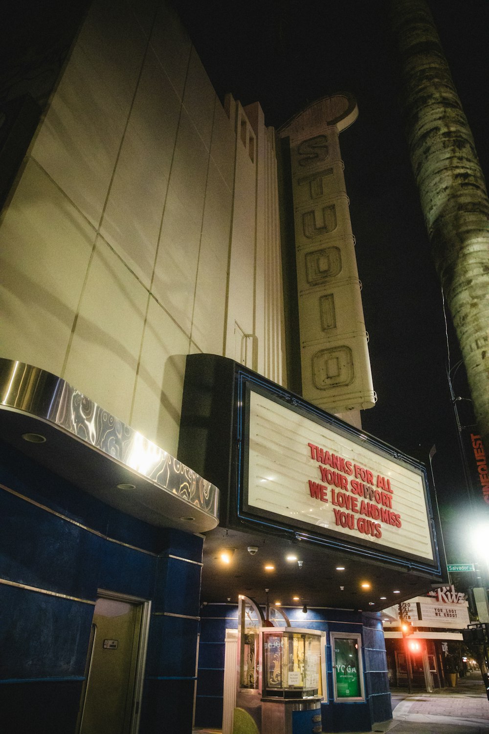 a theater marquee on a city street at night